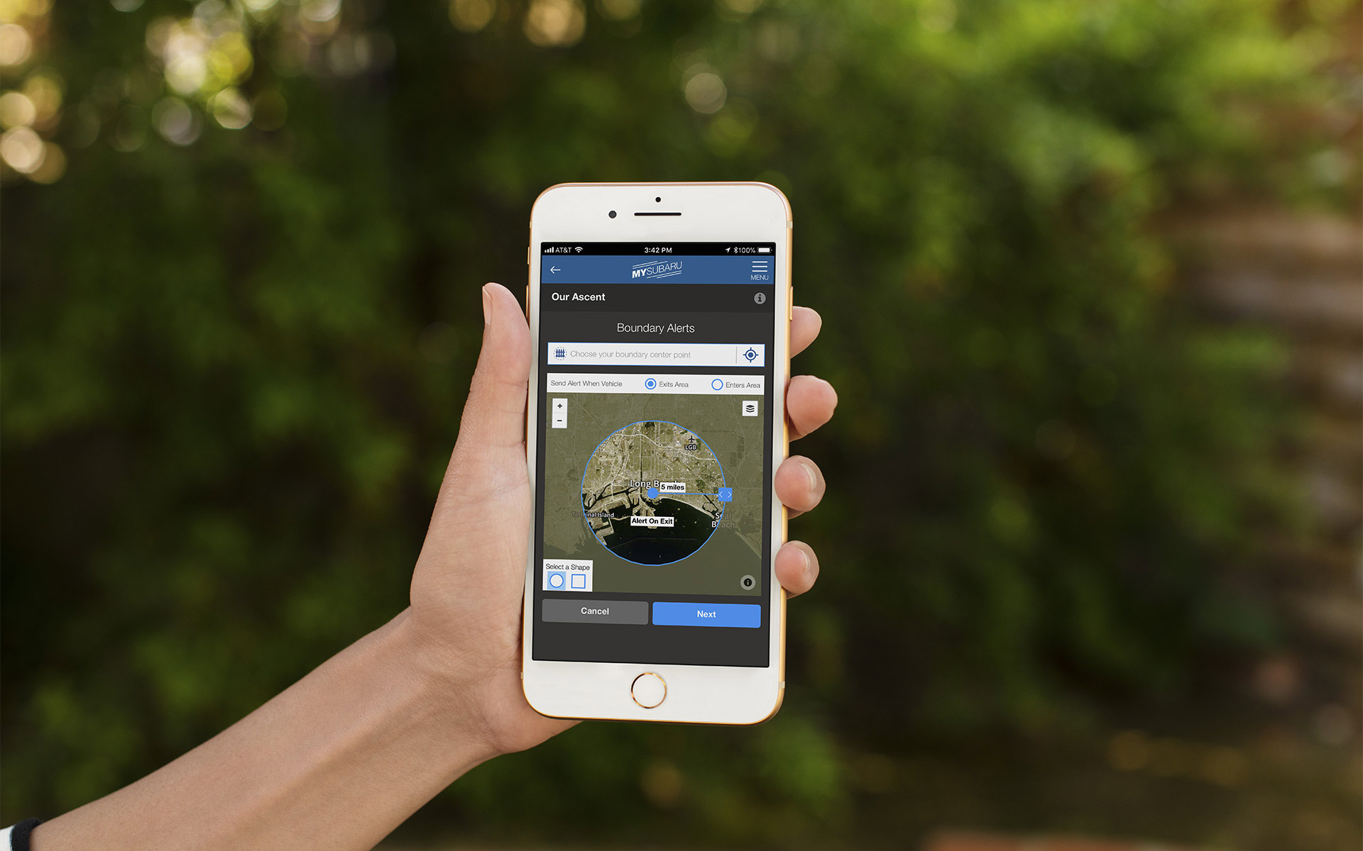 Hand holding an iPhone with the Boundary Alerts page pulled up on the MySubaru app.