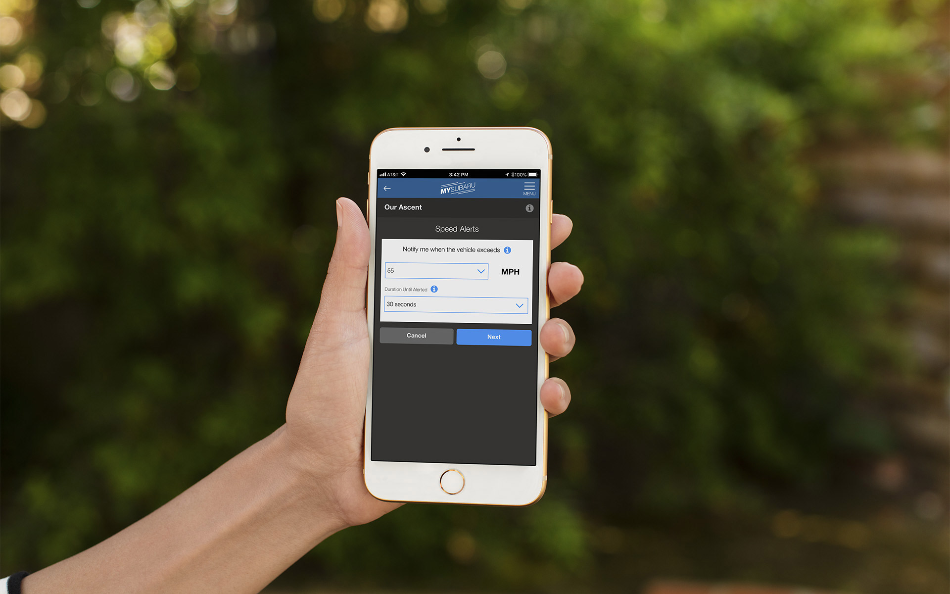Hand holding an iPhone with the Speed Alerts page pulled up on the MySubaru app.