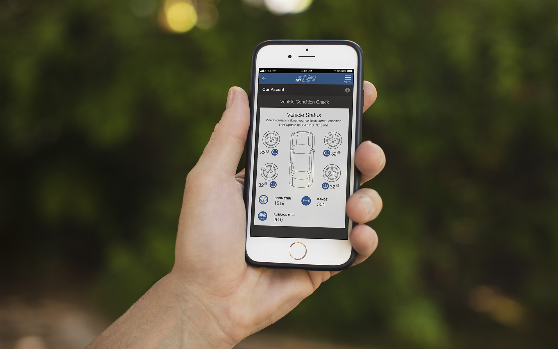 Hand holding an iPhone with the Vehicle Condition Check page pulled up on the MySubaru app